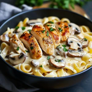 Creamy chicken and mushroom pasta topped with parsley in a white bowl