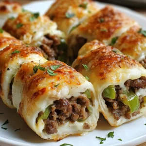 Close-up of cheesy Philly cheesesteak roll ups served on a white dish