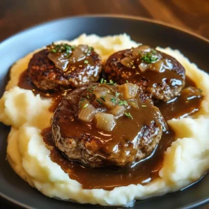 Plate of Salisbury steak topped with mushroom and onion gravy, served with garlic mashed potatoes